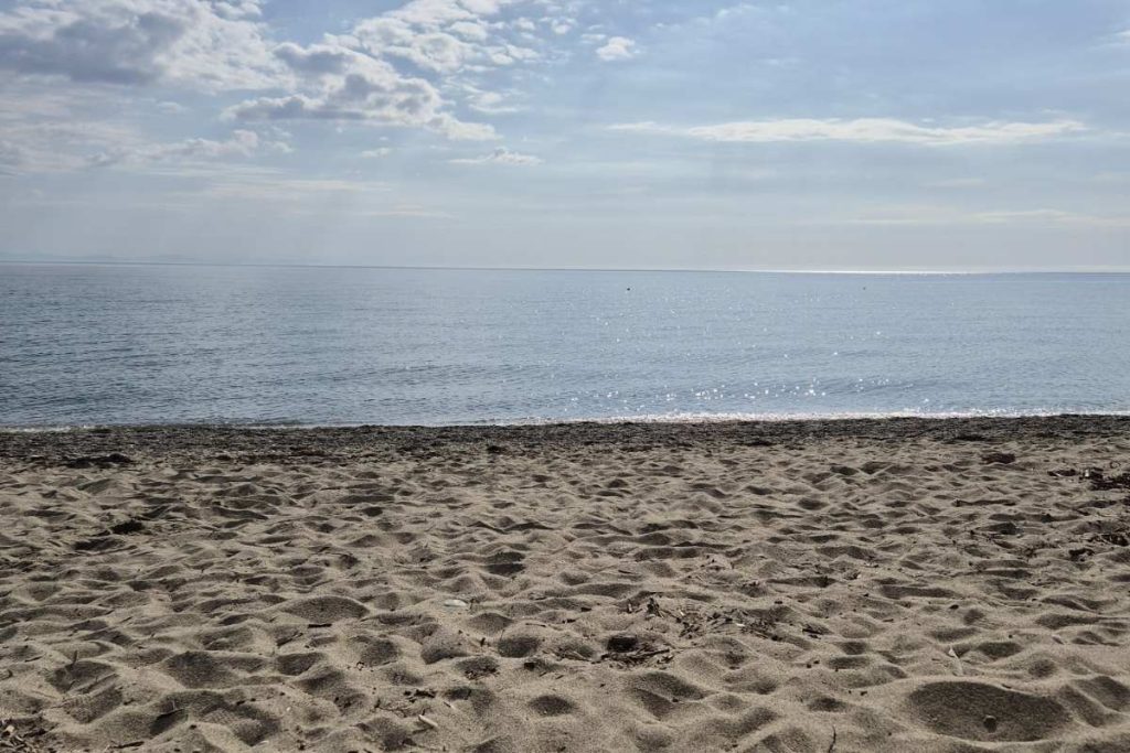 Peščana plaža i mirno more u Olympic Beachu u Grčkoj