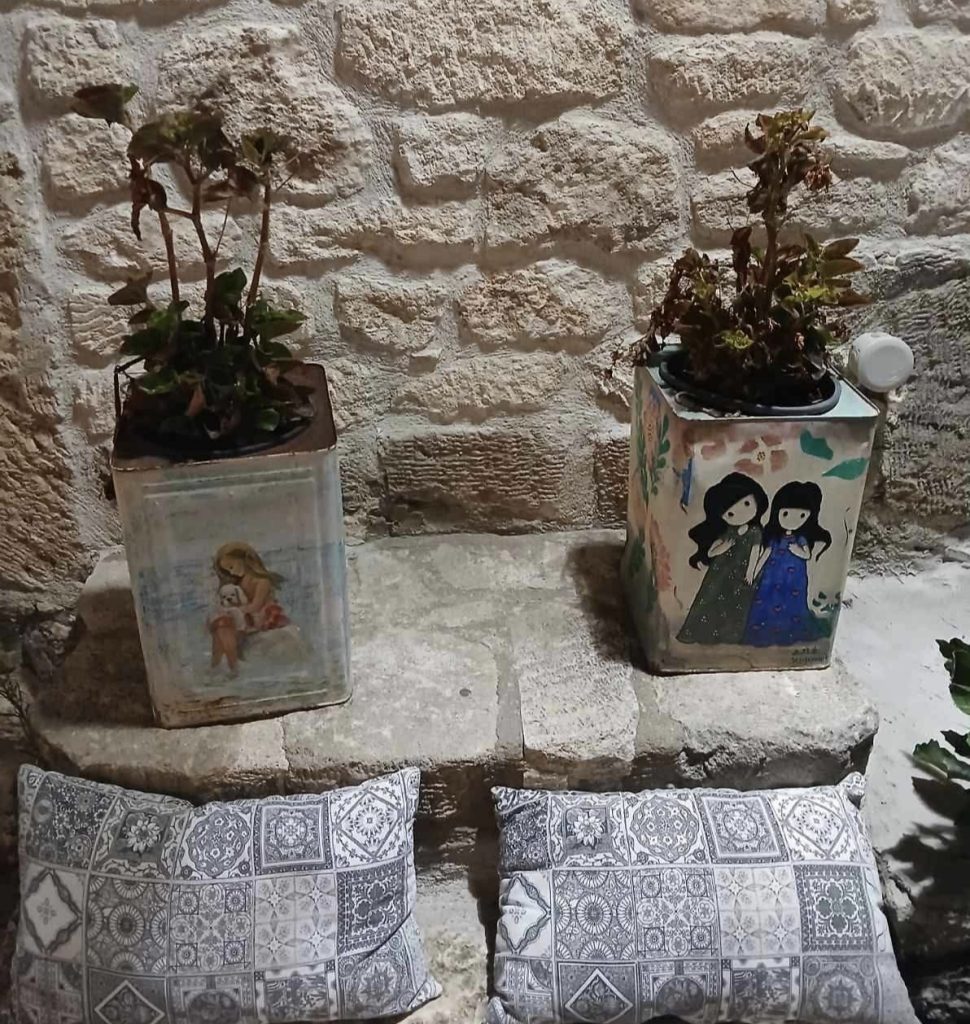 Dekorativne saksije i jastuci uz kameni zid u starom delu Afitosa na Halkidikiju